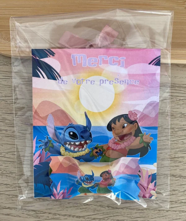 Sachet avec cartes de remerciement personnalisées Lilo et Stitch, posés sur un plateau en bois.