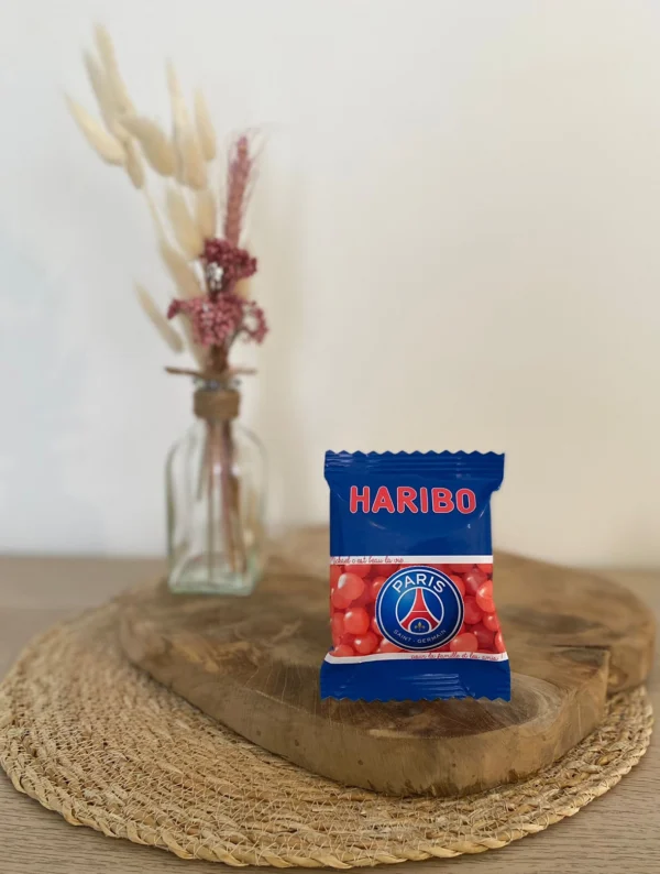 Sachet Haribo personnalisé avec le logo du PSG, posé sur un support en bois.